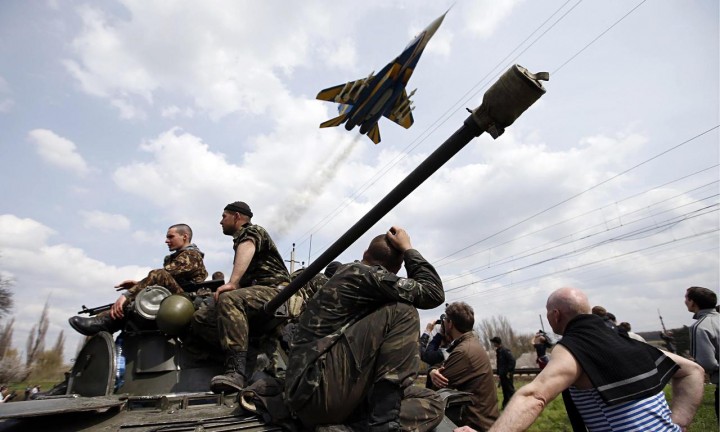 A fighter jet flies above Ukrainian soldiers in Kramatorsk