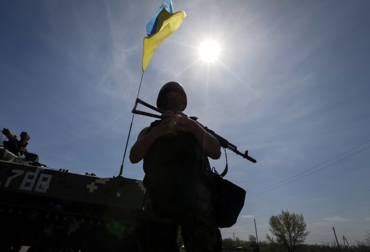 A Ukrainian soldier stands guard near an APC at a checkpoint outside the city of Slaviansk