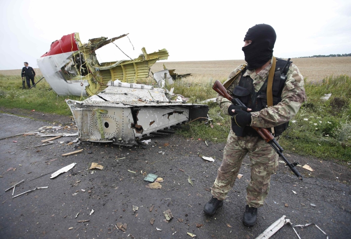 A pro-Russian separatist stands at the crash site of Malaysia Airlines flight MH17, near the settlement of Grabovo in the Donetsk region