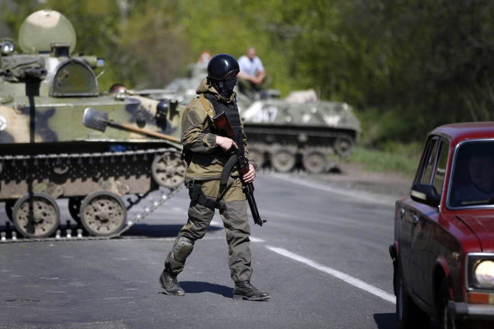 A Ukrainian soldier walks near armoured personnel carriers at a check point near Slaviansk