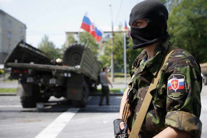 A member of a newly-formed pro-Russian armed group called the Russian Orthodox Army mans a barricade near Donetsk airport