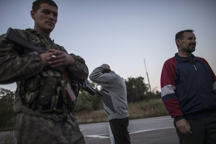 Members of the Ukrainian government forces, who are prisoners-of-war (POWs) react next to an Ukrainian soldier after they were exchanged, north of Donetsk, eastern Ukraine