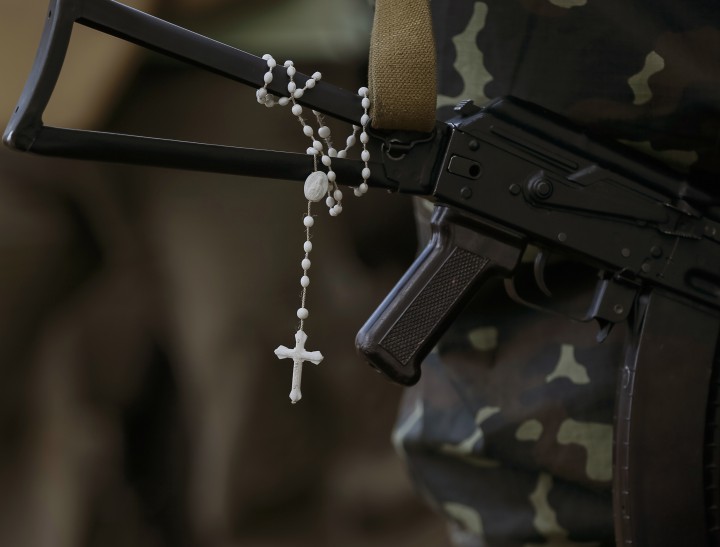 A rosary hangs for a machine gun as Ukrainian soldiers stands at their positions near the eastern Ukrainian town of Pervomaysk