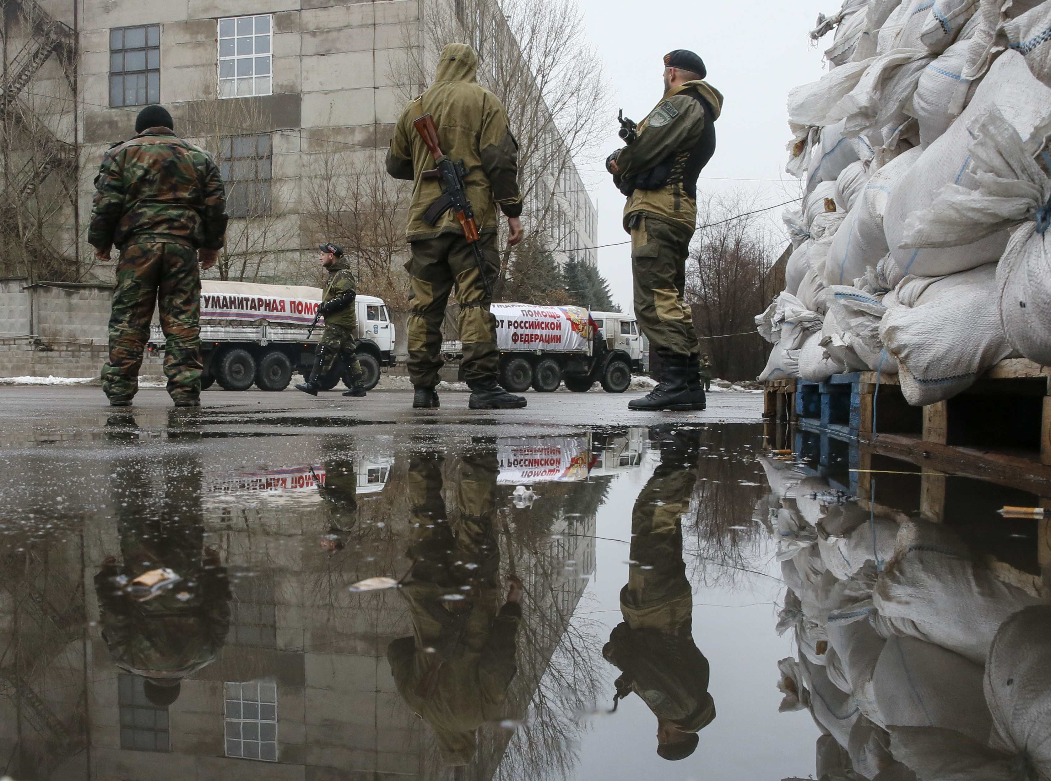 Pro-Russian separatists patrol the street in front of Russian humanitarian trucks in Makiivka in Donetsk region