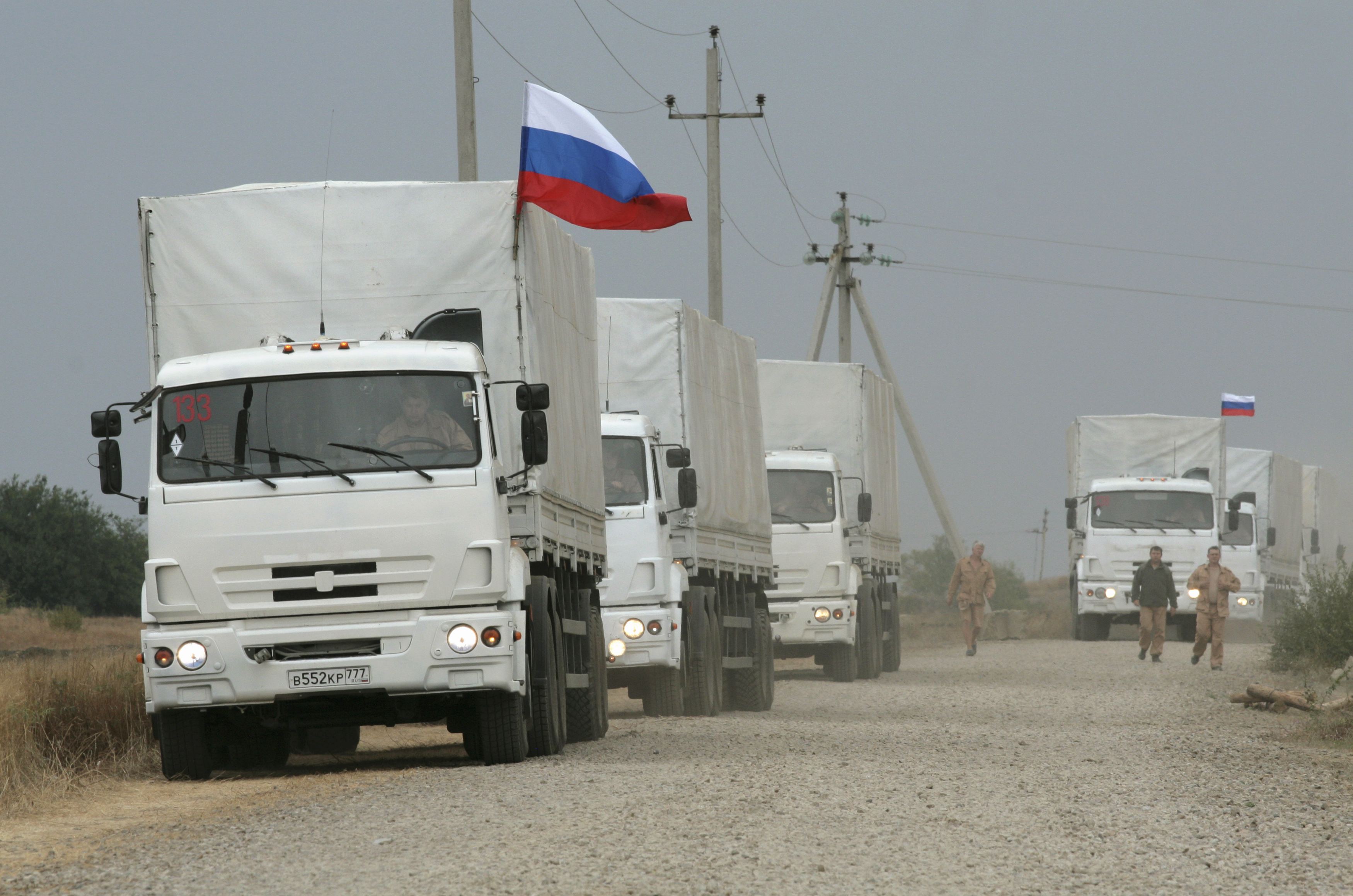 A Russian convoy of trucks carrying humanitarian aid for Ukraine are parked by the side of a road near Kamensk-Shakhtinsky
