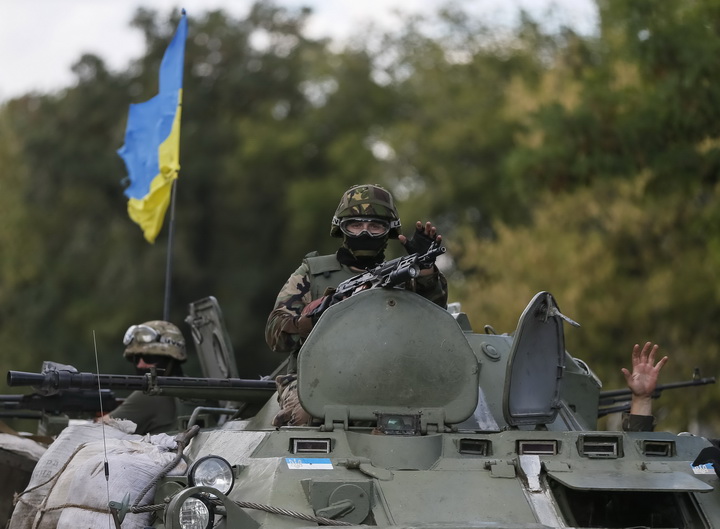 Ukrainian servicemen ride in an armoured vehicle near Debaltseve