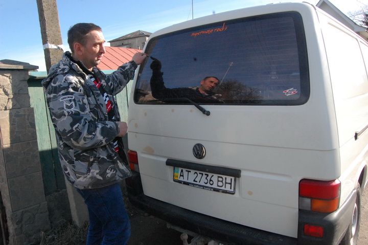 Віталій Федьків показує сліди від куль, які прошили його авто