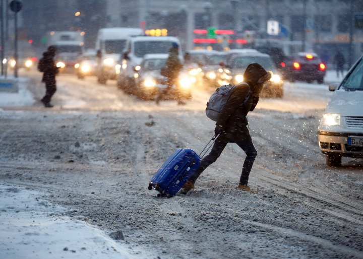 Pedestrians cross a street near the snow covered boulevard Unter den Linden after heavy snowfall in the German capital Berlin