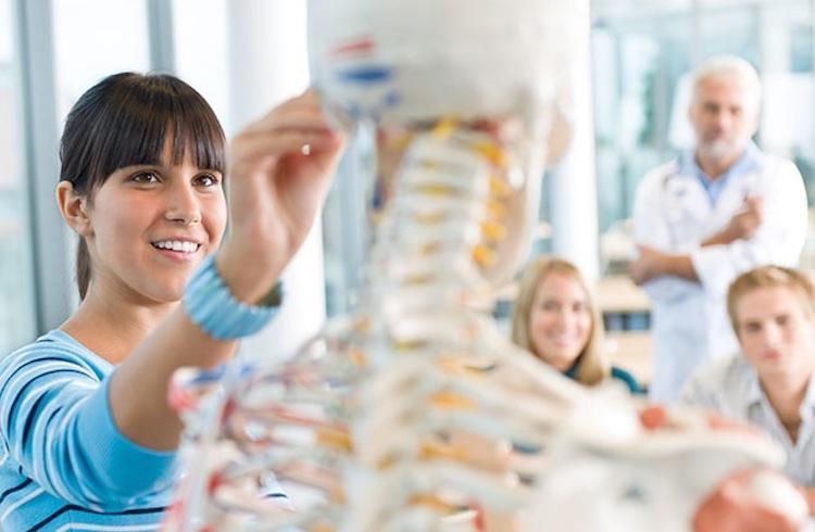 Medical students and professor with skeleton