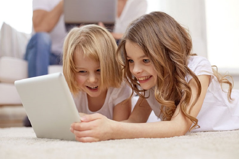happy little girls with tablet pc computer at home