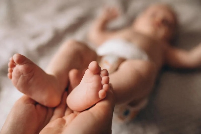mother-holding-newborn-baby-feet